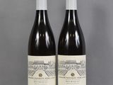 deux bouteilles de vin posées sur une table l'une à côté de l'autre