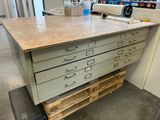 a table with drawers on it in the middle of a room