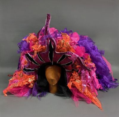 chapeau à plumes violet, orange et rose sur une tête de mannequin