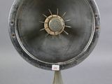 a large metal object on a stand with a clock on it