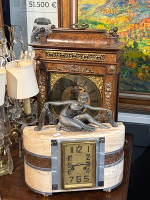une horloge posée sur une table à côté d'un tableau