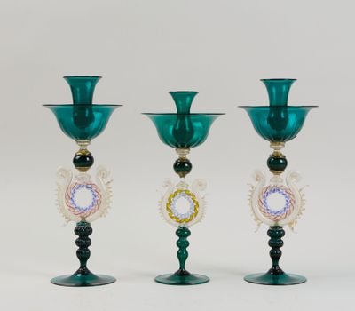 trois vases en verre vert posés sur une table blanche
