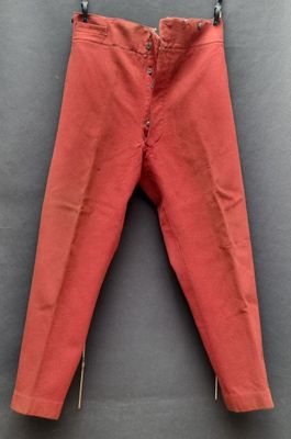 un pantalon rouge suspendu à une corde à linge