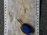 une clé de voiture posée sur un bout de papier à côté d'une calculatrice