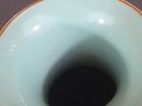 a blue vase with a gold rim sitting on a table