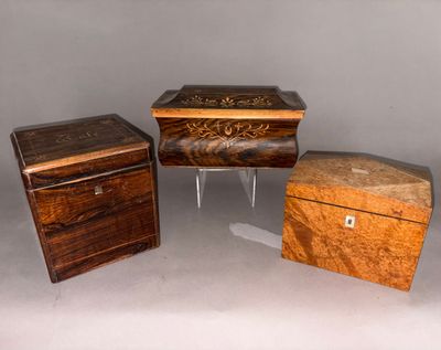 Trois petites boîtes en bois sont posées les unes à côté des autres sur une table