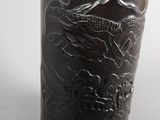 a black vase with a picture of a mountain on it
