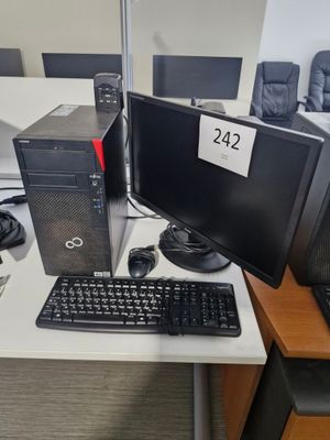 un ordinateur de bureau posé sur une table avec un clavier et une souris