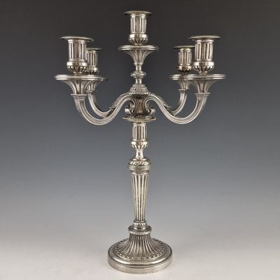 a silver plated candelab with five candles on a stand