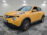 Le SUV Nissan Juke jaune est garé dans une grande pièce.