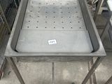 une table en métal sur laquelle est posé un plateau en métal