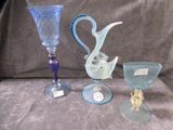 three wine glasses and a vase sitting on a table