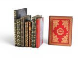 three books are lined up in a row on a white surface