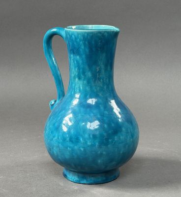 blue vase on a gray surface with a gray background