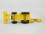 a yellow toy truck that is sitting on a white surface