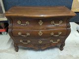 une commode en bois posée sur une table