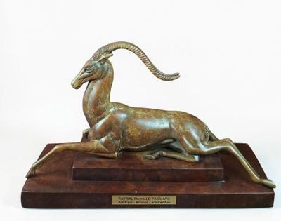 bronze statue of a ram on a wooden base with a plaque