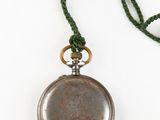 a silver pocket watch with a green cord on a white background