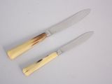 two knives that are sitting on a white surface