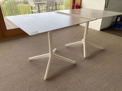 a white table with a white base in a living room