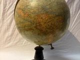 an old globe on a stand against a white backdrop