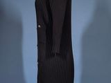 a black dress on a mannequin stand against a blue background