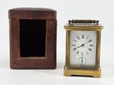 a small clock sitting next to a box on a table
