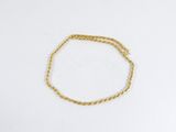 un bracelet en chaîne dorée sur un fond blanc