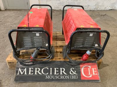 deux appareils de soudage rouges posés sur une palette dans un entrepôt