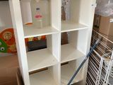a white bookcase with a lot of boxes on the floor