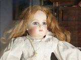 a doll that is standing next to a dresser