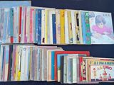 several children ' s books are stacked on a black surface