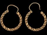 une paire de boucles d'oreilles en or sur fond noir