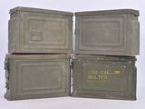 four military ammo cans stacked on top of each other on a white surface