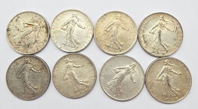 six types différents de pièces d'argent sur une surface blanche