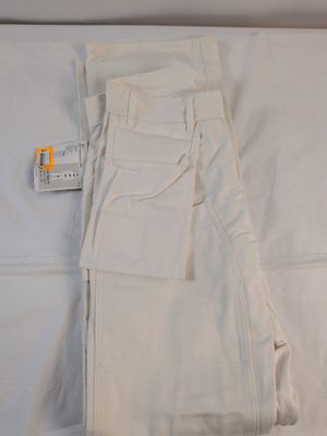 un pantalon blanc posé sur un lit