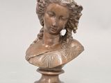 an antique bronze bust of a woman on a pedestal