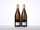two bottles of white wine sitting on top of a table