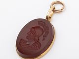 a close up of a pendant with a picture of a woman on it