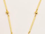 a gold plated necklace with labradorite beads on a white background