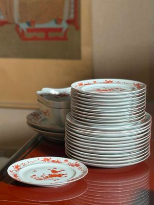 a stack of plates on a table with a picture on the wall in the background