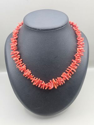 a necklace made of coral coral beads on a black mannequin