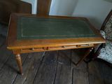 a small table with a green top on a wooden floor