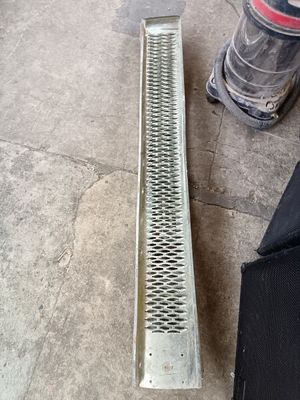 a metal grate laying on the floor next to a black bag