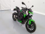 a picture of a green motorcycle parked in a garage