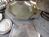 a table with a lot of silver plates and silver dishes on it