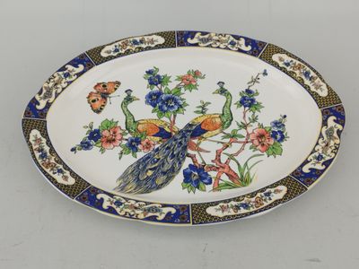 une assiette décorée d'un paon et de fleurs