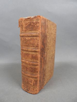 an old book sitting on top of a table next to a gray background
