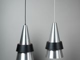 deux lampes en métal suspendues au plafond dans une pièce grise