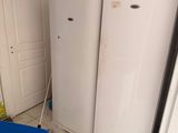 un réfrigérateur blanc et une poubelle bleue dans une cuisine